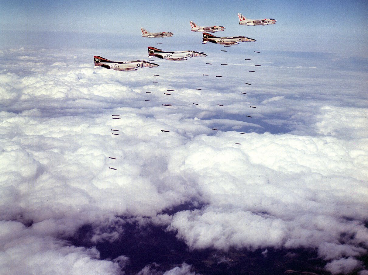 Three U.S. Navy McDonnell F-4B Phantom II of Fighter Squadron 161 (VF-161) Chargers and three Ling-Temco-Vought A-7C Corsair II of Attack Squadron 86 (VA-86) Sidewinders during a Loran-guided strike mission over Vietnam, March 1973.
